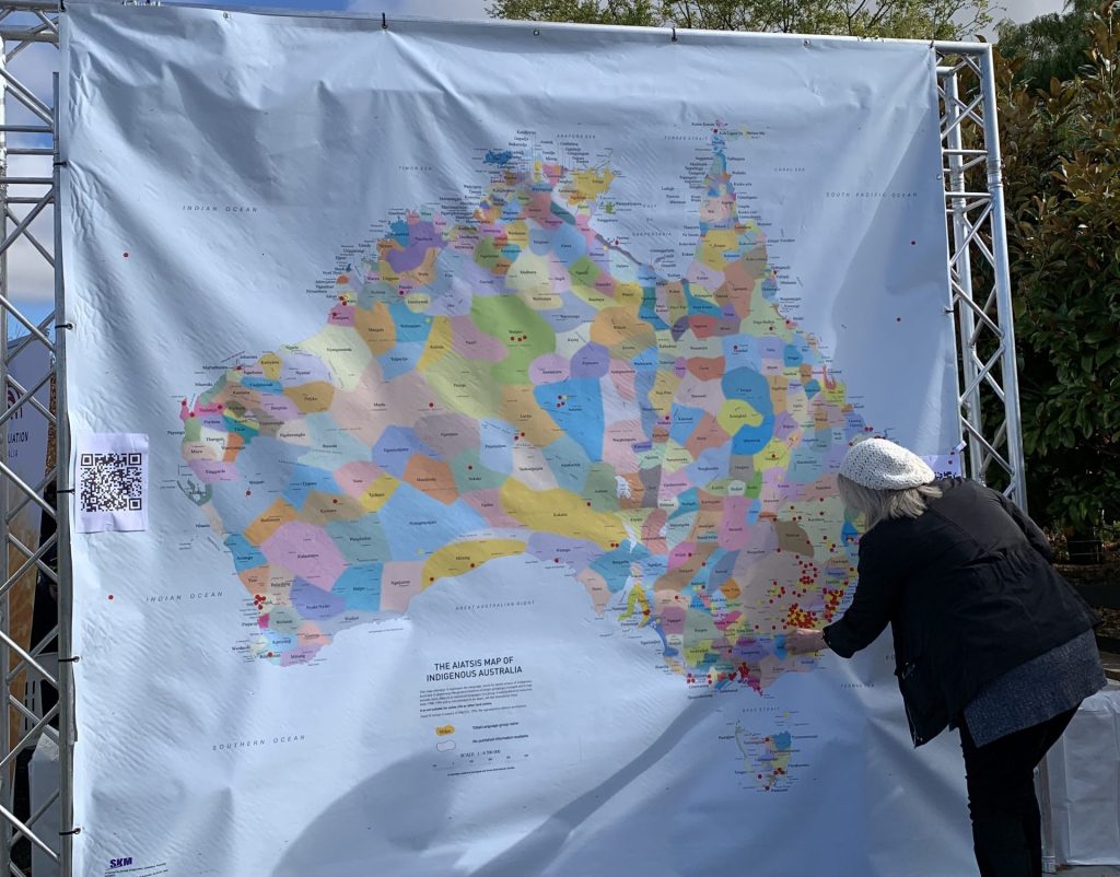 Person places a sticker on the AIATSIS map of Indigenous Australia